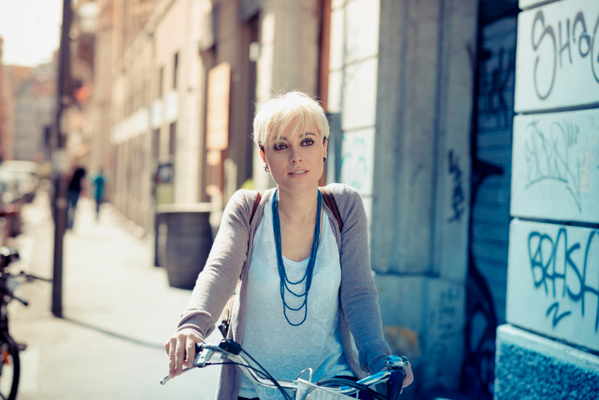 beautiful young blonde short hair hipster woman witk bike in the city